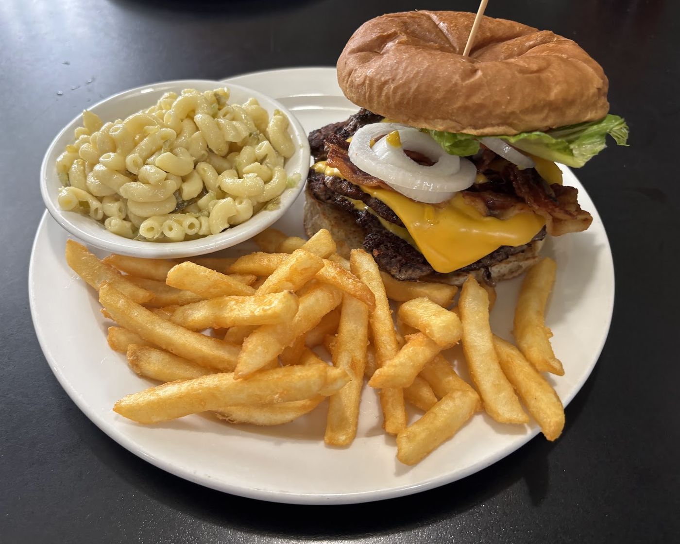 A double bacon cheeseburger on a hand-made patty with fries and macaroni salad